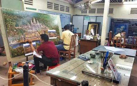 Photo d'artisans cambodgiens en train de peindre une toile à Angkor.