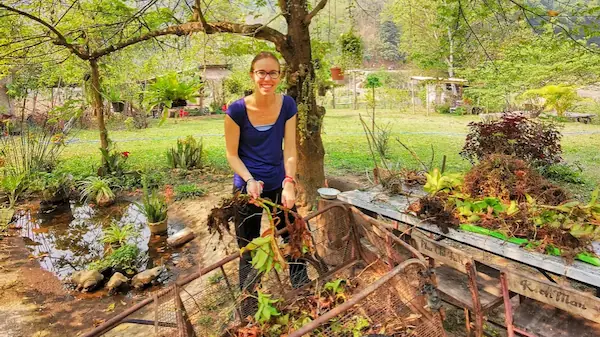 Une fille s'occupe des plantes dans un jardin