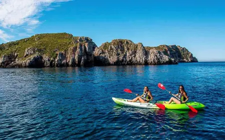 Deux personnes font du Kayak devant des falaises à Majorque