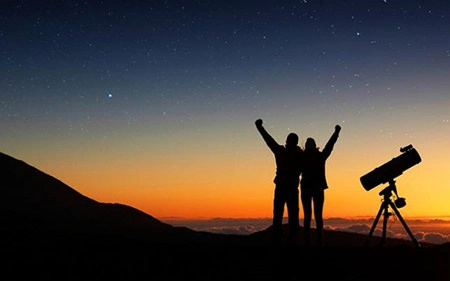 Deux personnes observent les étoiles de nuit à Tenerife